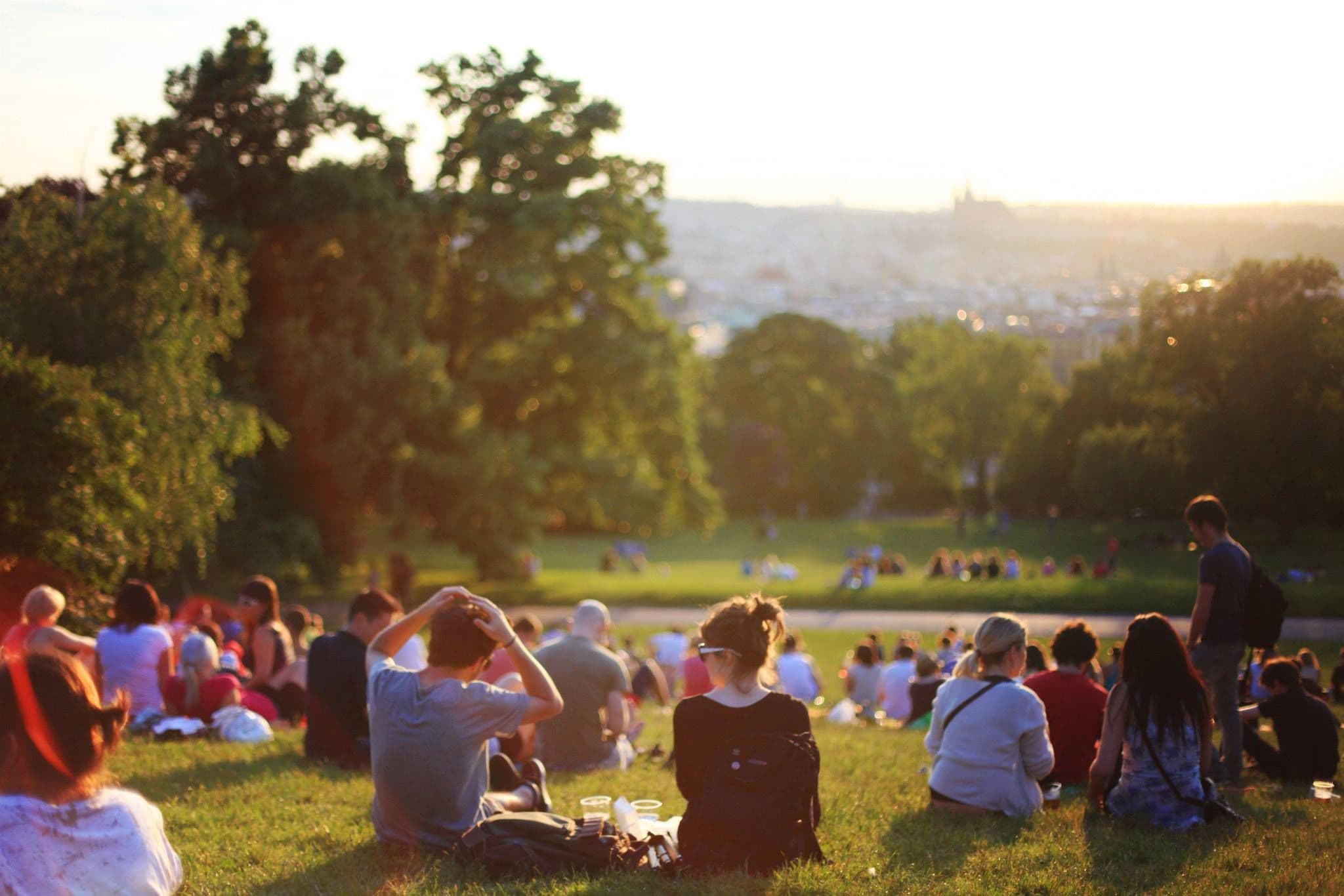 Friends relaxing on a sunny hillside park overlooking the city